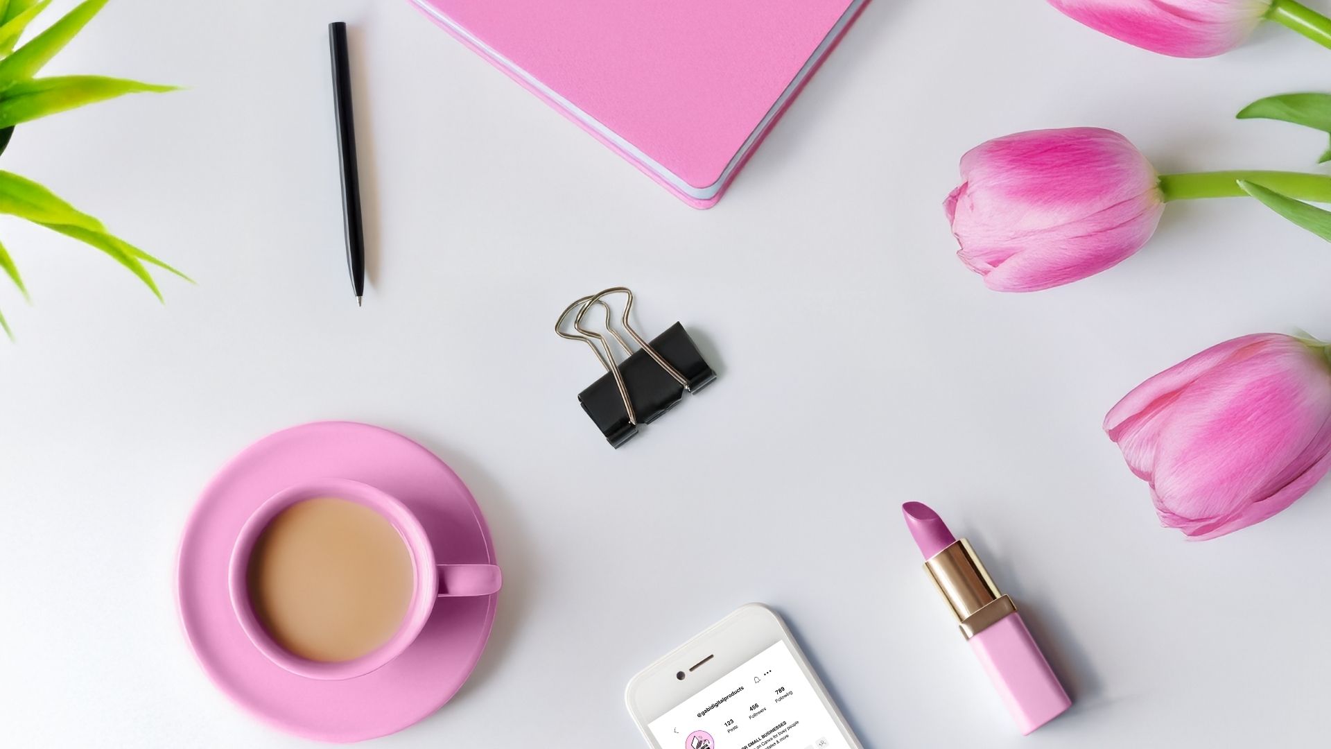 Desk with pink notebook, stationery, flat lay for How to Market Digital Products on Pinterest blog.
