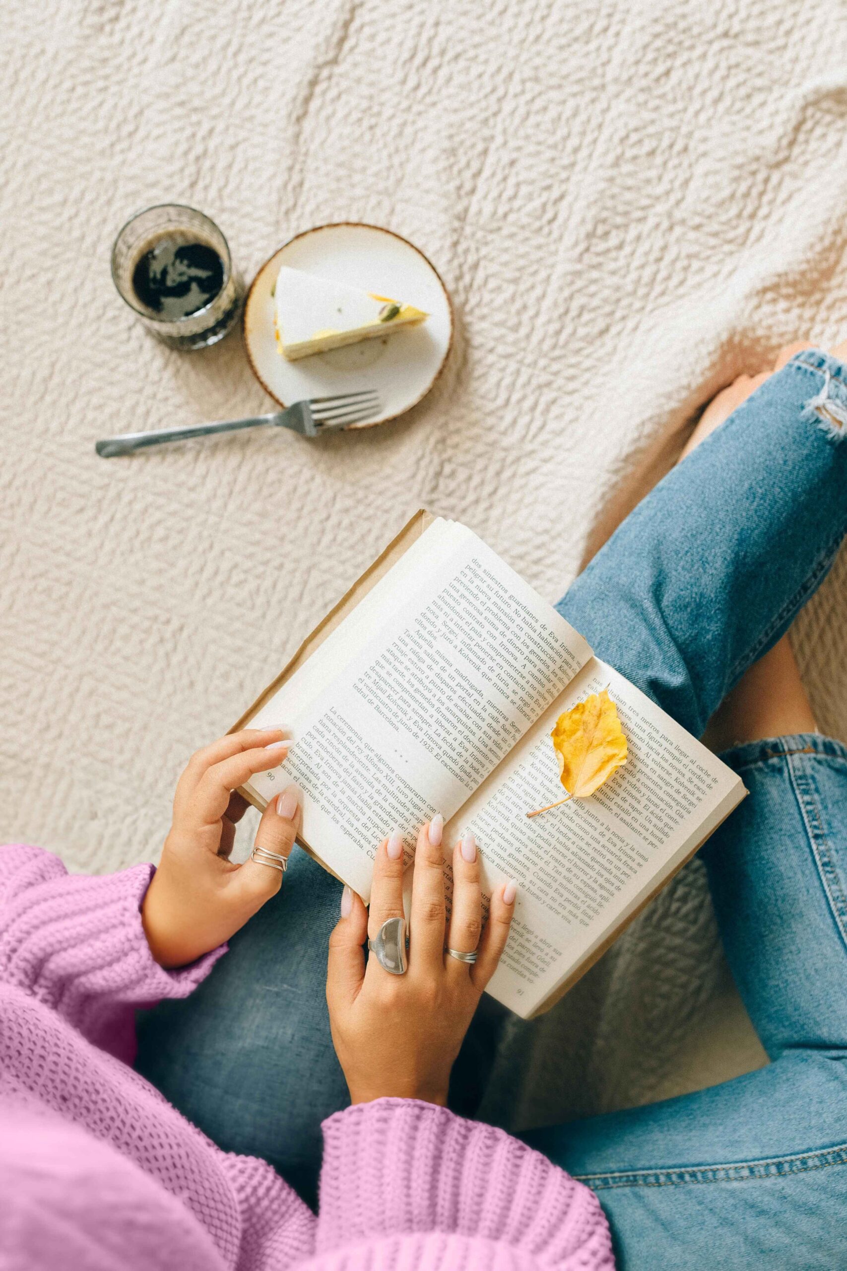 Woman reading on bed, enjoying cake and drink—ideal for beginners learning to sell digital products.