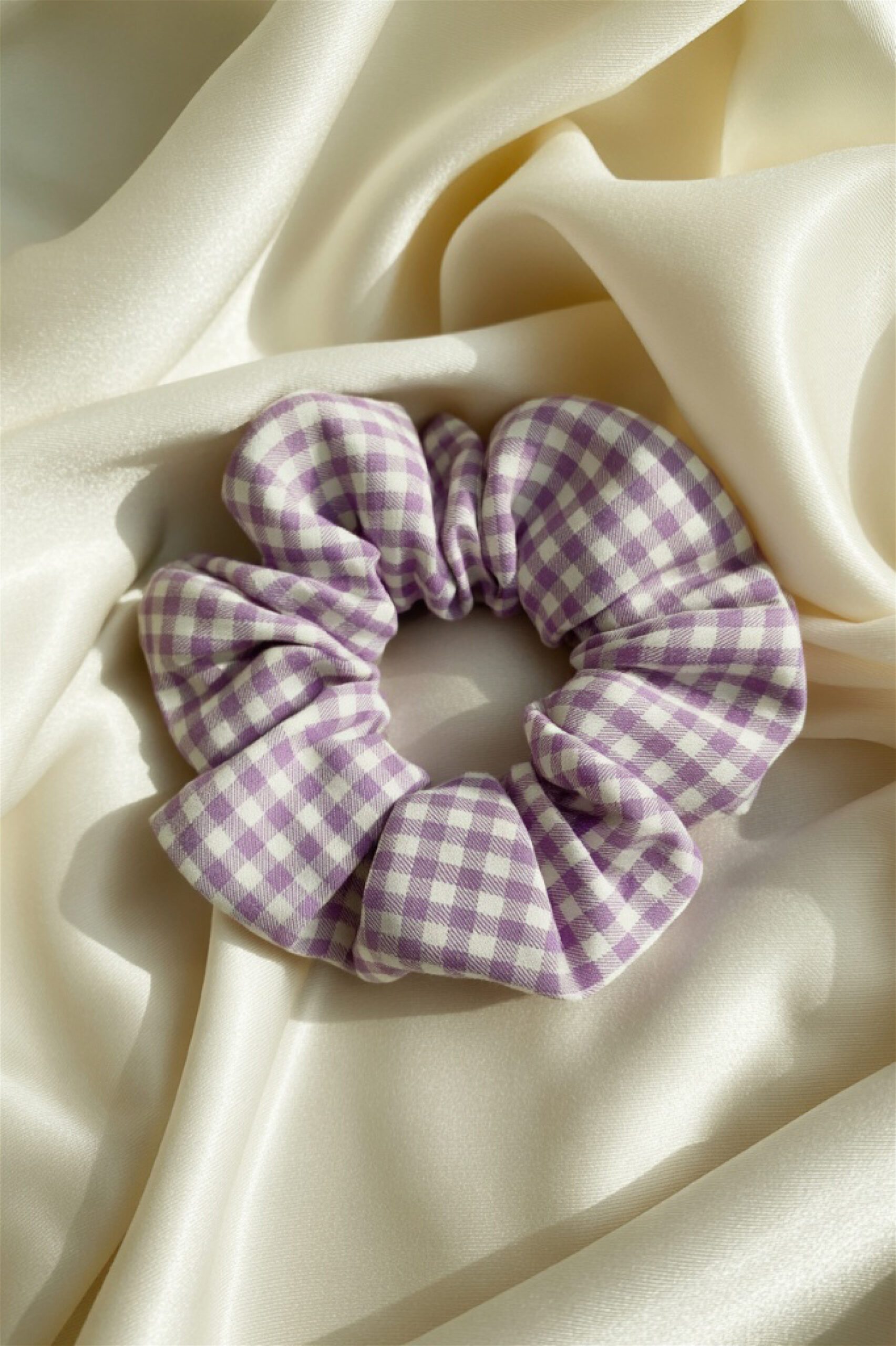 Close-up of a light lavender and white striped fabric hair accessory.