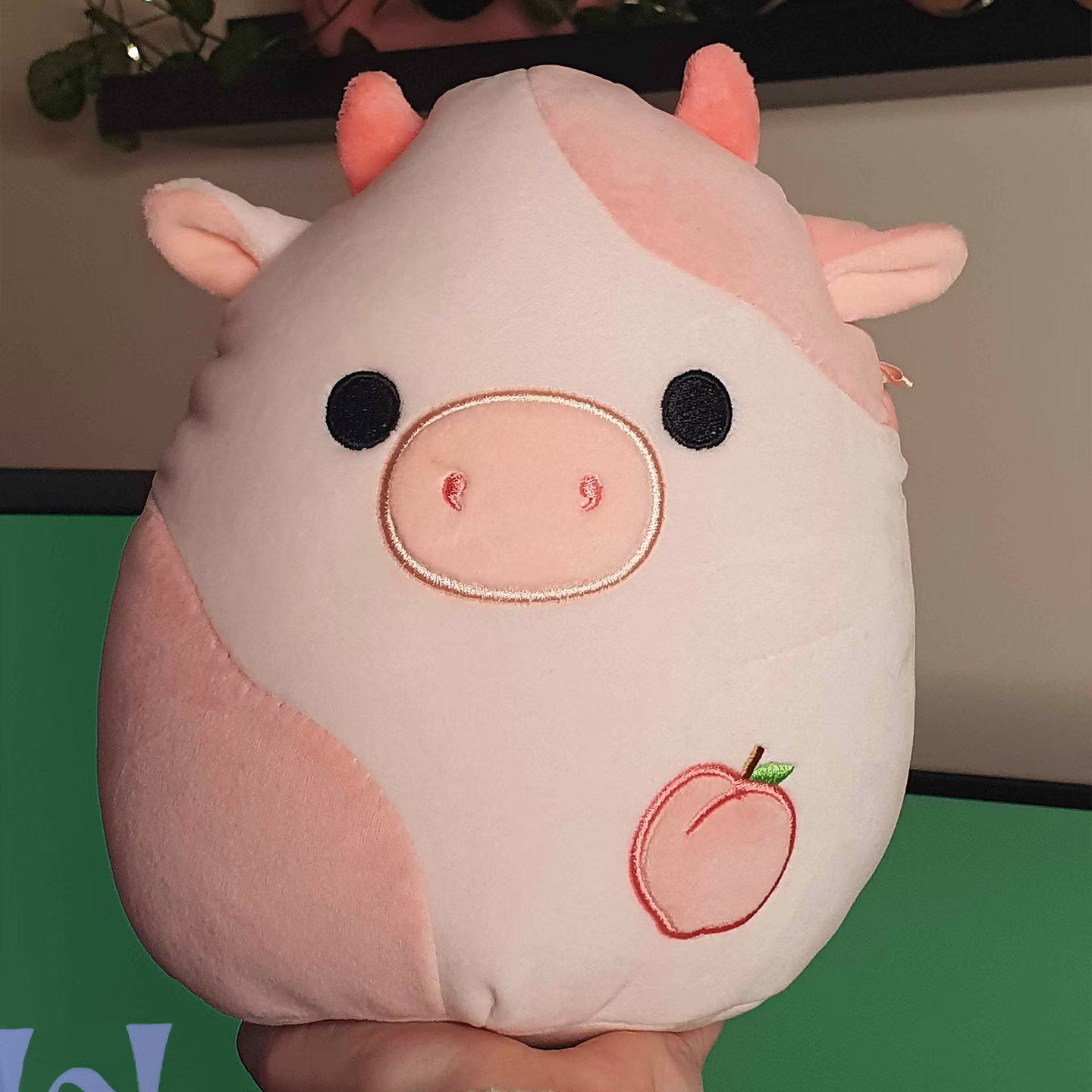 Aesthetic pink office decor - Squishmallows Peach Cow plush for a cozy small desk setup.